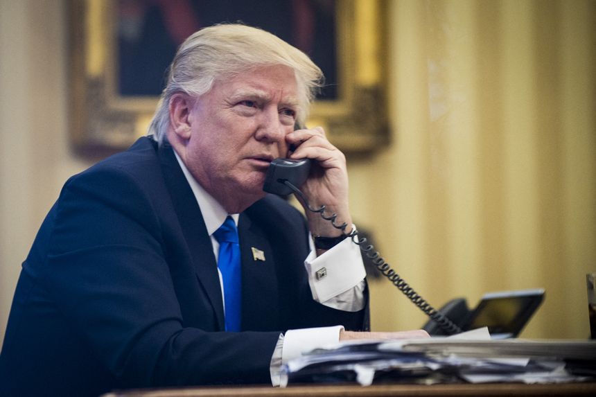 Donald Trump talks on the phone in the Oval Office.