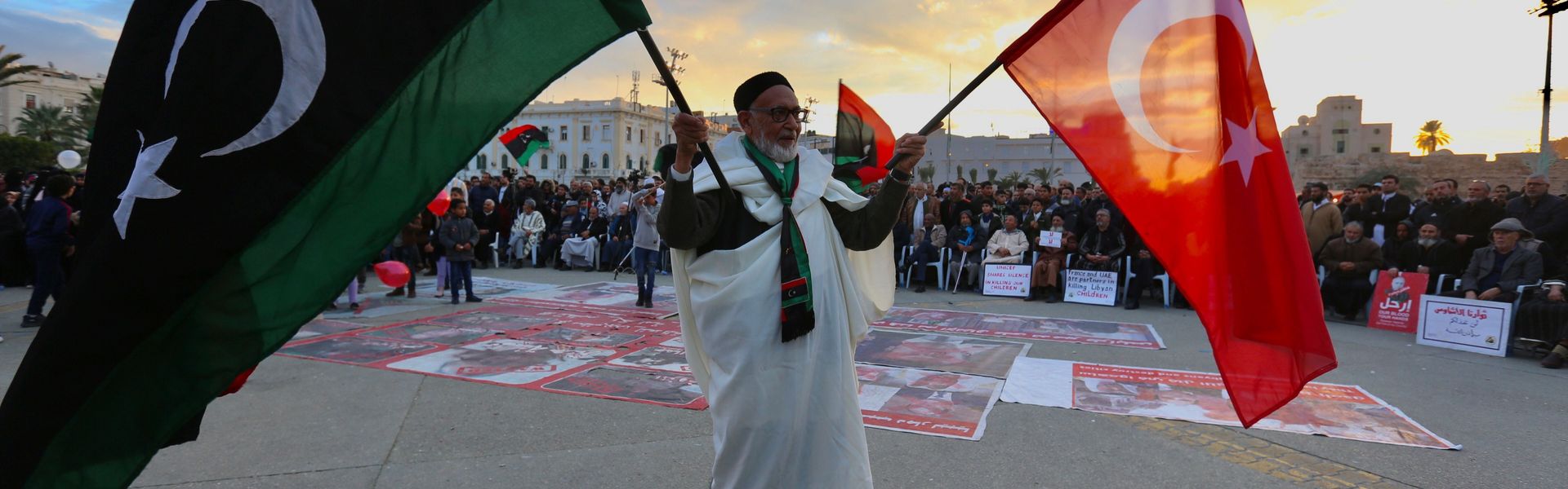 An elderly man holds Turkish and Libyan flags during a protest in Tripoli's Martyrs' Square on January 10, 2020, against eastern military commander Khalifa Haftar and in support of the UN-recognized Government of National Accord (GNA).